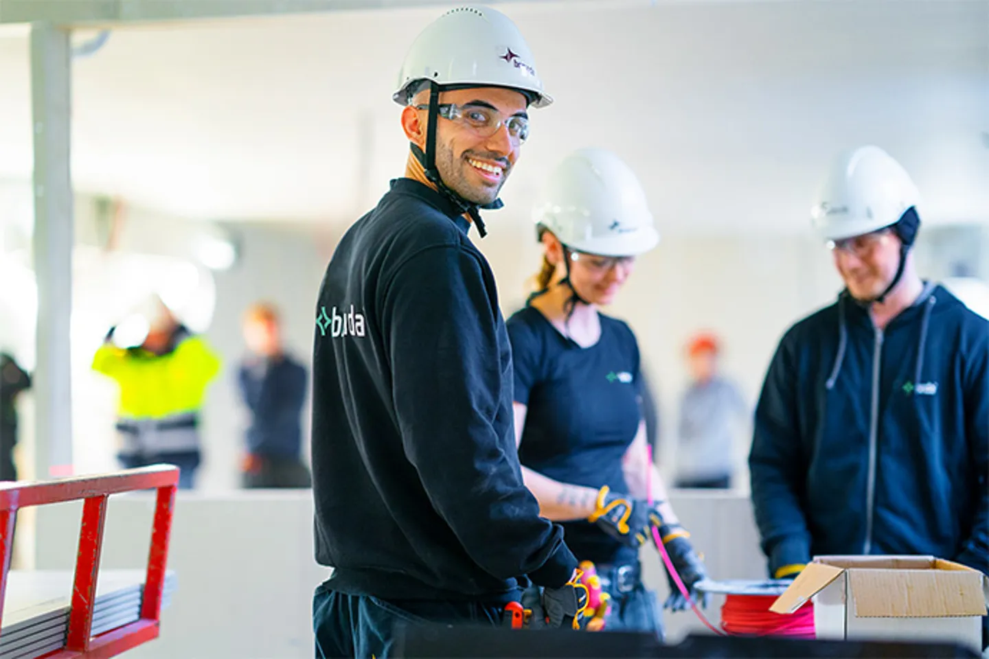Tre stycken elektriker på en byggarbetsplats