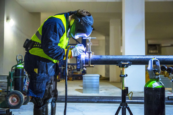 En montör hos Bravida gör svetsarbeten 