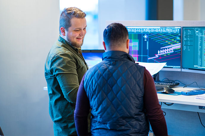 Två medarbetare i samtal vid datorskärmar